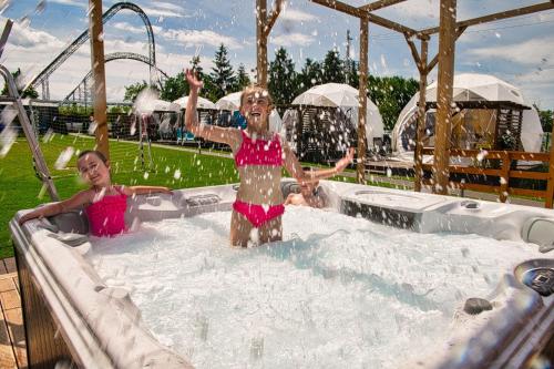 two girls are standing in a hot tub at Holiday Park Zator in Zator
