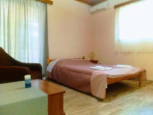 a bedroom with a bed and a couch and a table at Oropos Memories House in Skala Oropou