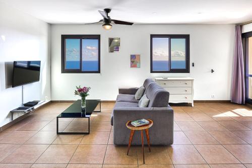 - un salon avec un canapé et une télévision dans l'établissement Bleu Horizon, à Saint-Leu