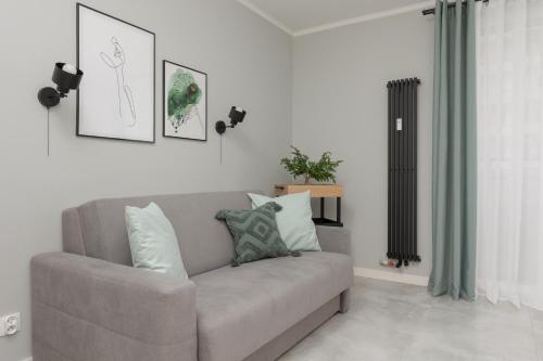 a living room with a couch with pillows on it at Cozy & Stylish Studio Ochota 1,5 km to Złote Tarasy by Renters in Warsaw