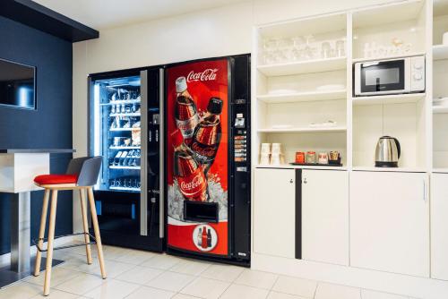 a cocacola soda vending machine in a kitchen at harry's home Linz-Urfahr hotel & apartments in Linz