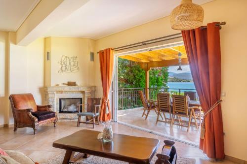 sala de estar con chimenea y mesa en Villa Pasithea, en Korfos