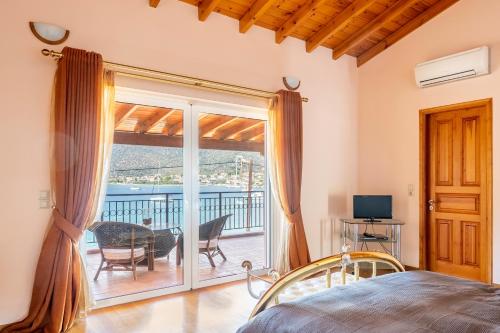 a bedroom with a bed and a sliding glass door at Villa Pasithea in Korfos