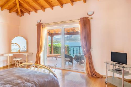 1 dormitorio con cama, TV y balcón en Villa Pasithea, en Korfos