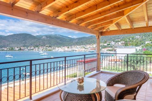 a table and chairs on a balcony with a view of the water at Villa Pasithea in Korfos