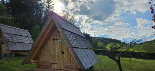 un pequeño edificio de madera con techo puntiagudo en Glamping - Kamp Steska, en Žalec