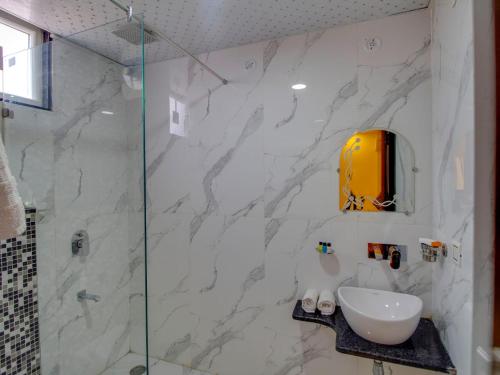 a bathroom with a sink and a glass shower at Jasoda Heritage By Keshav Global Hotels in Jaipur