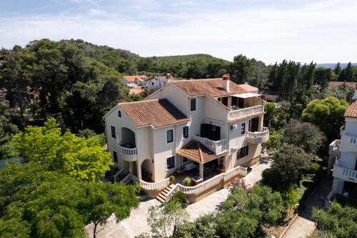 uma vista aérea de uma grande casa branca com árvores em Apartments Rozelyn em Ugljan