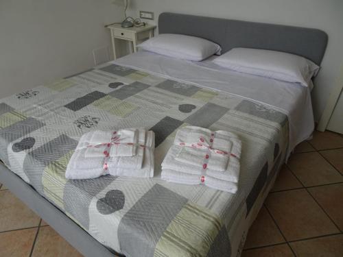 - un lit avec 2 paires de serviettes blanches dans l'établissement Appartamento Verdi Colline, à Moniga del Garda