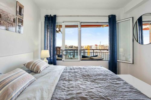 una camera con un letto e una grande finestra di Torrevieja Los locos Beach Luz de mar, Apartment with sea views a Torrevieja