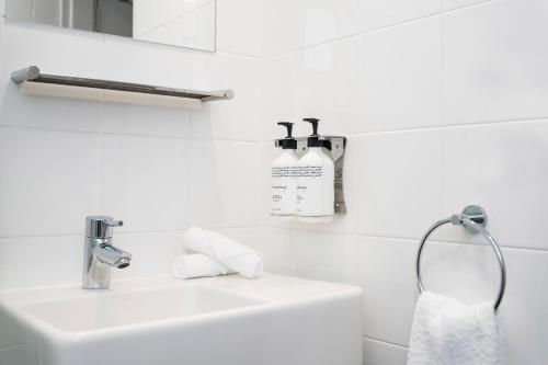 a white bathroom with a sink and a towel at Travelodge Hotel Hobart in Hobart