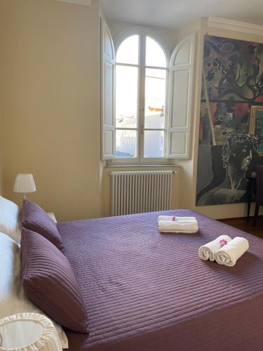 a bedroom with a purple bed with towels on it at Serena Apartment in Lucca