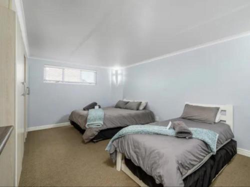 two beds in a room with white walls at The Slipway in Colchester