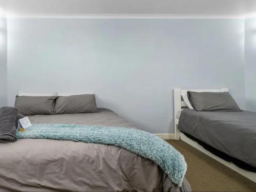 a bedroom with two beds and a white wall at The Slipway in Colchester