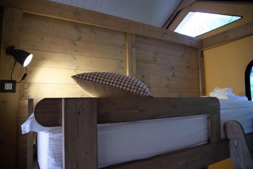 a bed in a room with a wooden wall at Agriturismo Podere Prataccio in Scansano