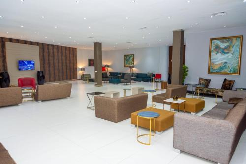 een grote lobby met banken, tafels en stoelen bij Hotel Embaixador in Beira