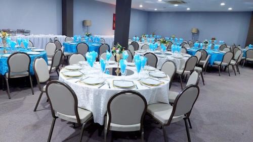 un grupo de mesas y sillas en una habitación en Hotel Embaixador, en Beira