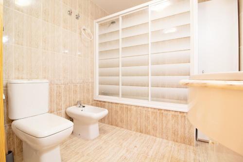 a bathroom with a toilet and a sink at Global Properties, Apartamento con piscina y terraza en Canet playa in Canet de Berenguer