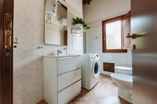 een badkamer met een wasmachine en een toilet bij Villetta Gio in Olìa Speciosa