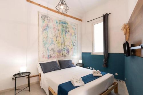 1 dormitorio con 1 cama y una gran pintura en la pared en DOMUS en Castellammare del Golfo