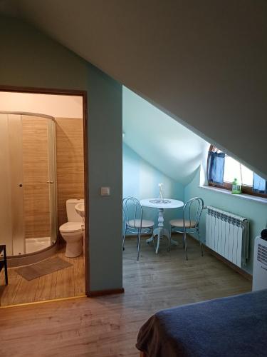 a room with a toilet and a table with chairs at Rybakówka in Rejowiec