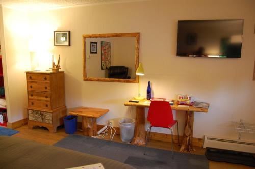 a bedroom with a desk and a mirror and a red chair at Gore Mountain Lodge in North Creek