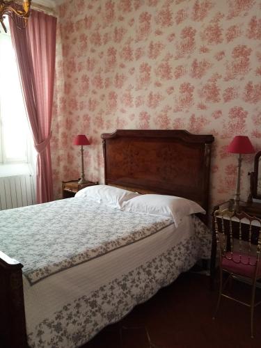 a bedroom with a bed with pink floral wallpaper at Maison Ville-Limoux in Limoux