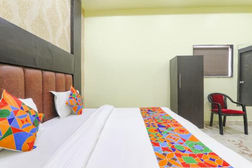 - une chambre avec un lit et une chaise rouge dans l'établissement FabExpress GS Residency, à Varanasi