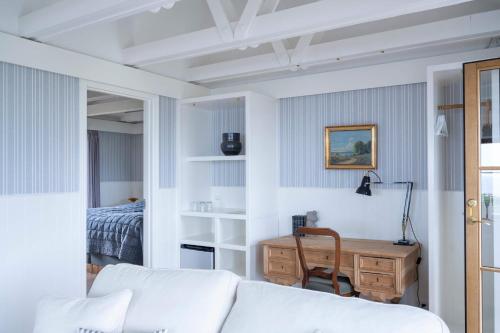 a living room with a white couch and a desk at Stammershalle Badehotel in Bådsted