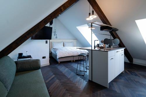 a room with a kitchen and a bed in a attic at The Lubo - self check-in in Luzern