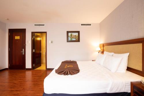 a hotel room with a large bed with white sheets at Aristo Saigon Hotel in Ho Chi Minh City