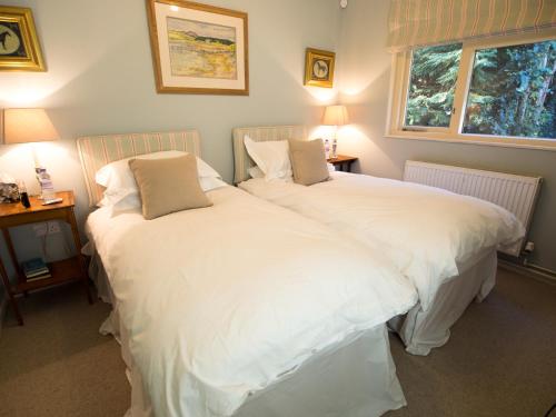 dwa łóżka siedzące obok siebie w sypialni w obiekcie Whole of Yew Tree Cottage Sleeps 4 w mieście Maidford