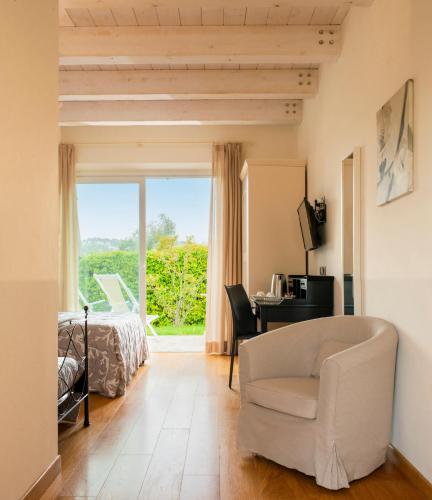 a bedroom with a bed and a desk and a chair at Hotel Giardino Suites&Spa in Numana