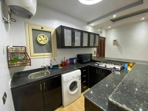 a kitchen with a sink and a washing machine at Amwaj Compound in Hurghada