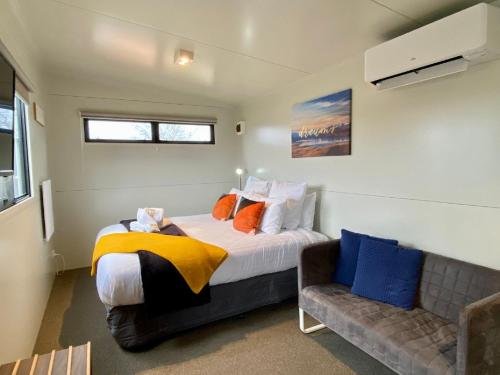 ein Schlafzimmer mit einem Bett und einem Sofa in der Unterkunft Stunted Totara, Unit 4 in Twizel
