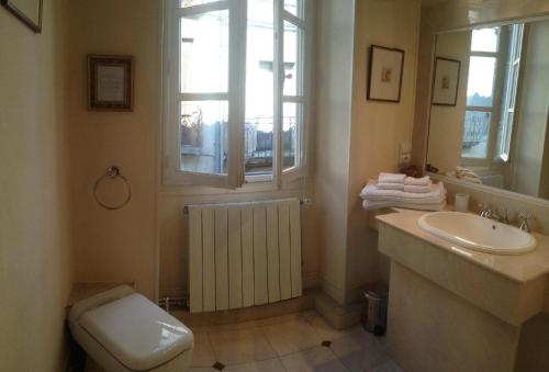 a bathroom with a sink and a toilet and a window at Maison Ville-Limoux in Limoux