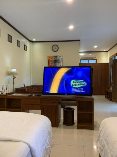 a living room with a flat screen tv in a room at Hotel & Villa Bukit Indah Saumlaki by LeGreen in Saumlaki