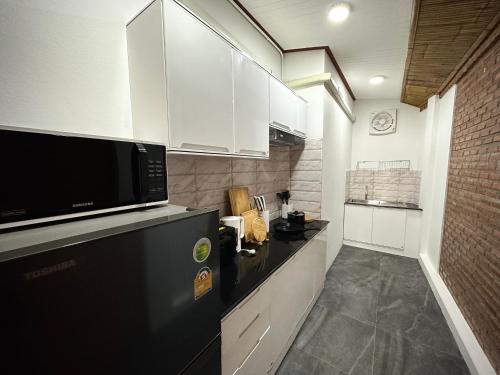 a kitchen with white cabinets and a black counter top at Villa Vara - Tropical Pool Villa in Ao Nang Beach