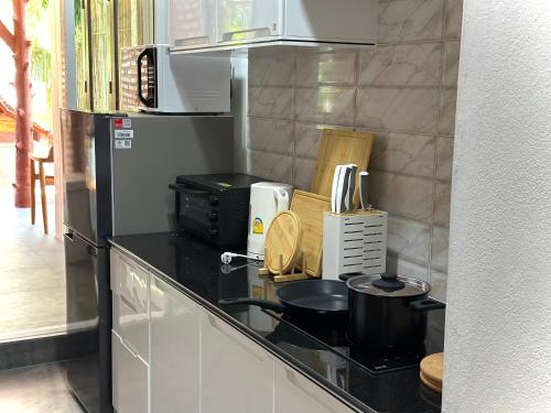 a kitchen with a black counter top with appliances at Villa Vara - Tropical Pool Villa in Ao Nang Beach