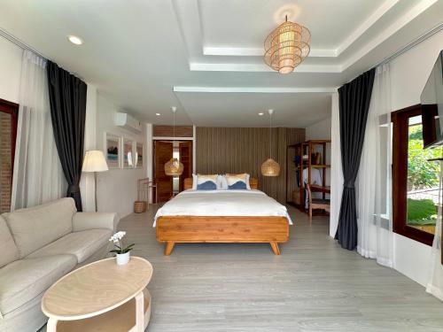 a bedroom with a bed and a couch at Villa Vara - Tropical Pool Villa in Ao Nang Beach