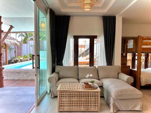 sala de estar con sofá y mesa en Villa Vara - Tropical Pool Villa, en Ao Nang Beach