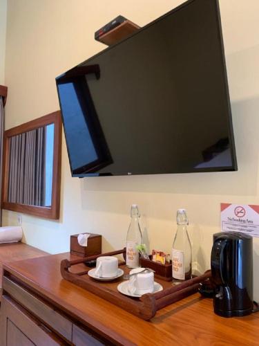 a tray with two bottles on a table with a tv at Hotel & Villa Bukit Indah Saumlaki by LeGreen in Saumlaki