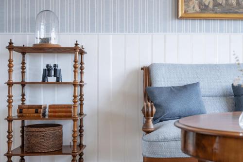 a living room with a blue chair and a table at Stammershalle Badehotel in Bådsted