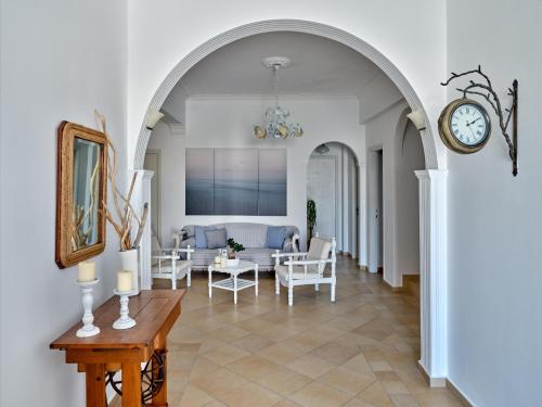 an archway in a living room with a couch and a clock at Hotel Galini in Naousa