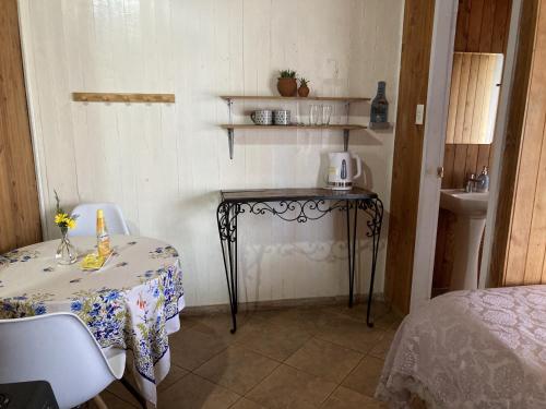 een kleine kamer met een tafel en een wastafel bij Hostal Centro Pucón A in Pucón