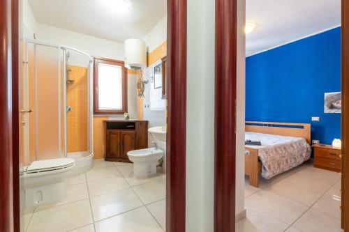 un bagno con un water, un letto e un lavandino di L Oasi della gatta panciona a Villasimius