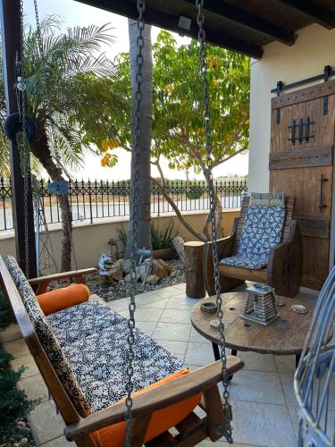 a porch with two chairs and a swing at Sotira Agia Napa Luxury House in Ayia Napa