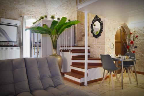 ein Wohnzimmer mit einer Couch und einem Tisch und einer Treppe in der Unterkunft Le Dimore del Garibaldi in Cassano delle Murge