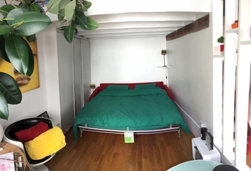 1 dormitorio con 1 cama con manta verde en Charming Parisian flat near Bastille, en París