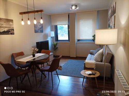 ein Wohnzimmer mit einem Tisch und einem Sofa in der Unterkunft Apartamento Piscina 2G by Urraca Suites Viveiro in Viveiro